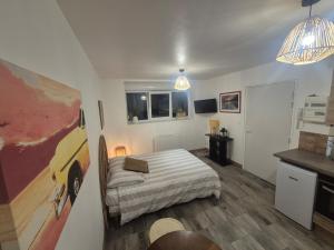 a bedroom with a bed and a painting on the wall at Comfortable one-story studio apartment in Péronne