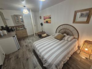 a bedroom with a large bed and a kitchen at Comfortable one-story studio apartment in Péronne