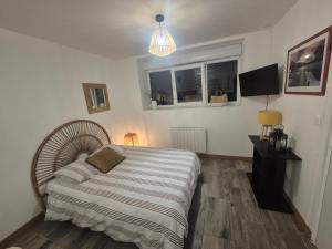 a bedroom with a bed and a lamp and two windows at Comfortable one-story studio apartment in Péronne