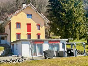 a house with red shutters on the front of it at La Rochetta in Chatel sur Montsalvens