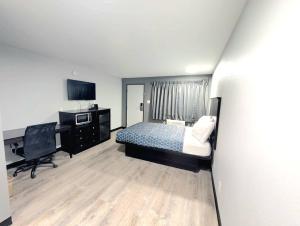 a bedroom with a bed and a desk and a computer at BlissPoint Inn Muncie in Muncie