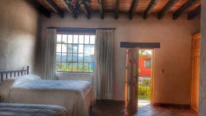 a bedroom with two beds and a window at El Macehual in San Miguel de Allende