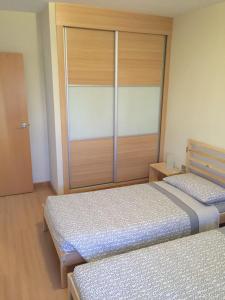 1 dormitorio con 2 camas y puerta corredera de cristal en Apartamentos EOS, en Buzanada