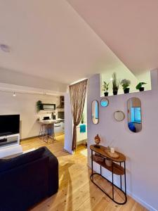 ein Wohnzimmer mit Sofa und Tisch in der Unterkunft Le Cocon Central avec Balnéo in Roanne