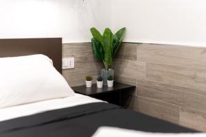 a bedroom with a bed with a plant on a side table at Suite Gli Ulivi in Colonna