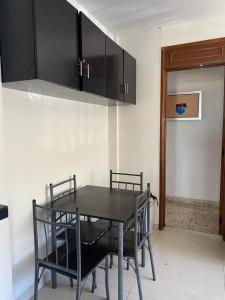 a dining room with a black table and chairs at Galeria Elementos, Tierra in Campeche +2 photos