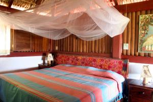 1 dormitorio con 1 cama con mosquitera encima en Villa Escondida en Zipolite