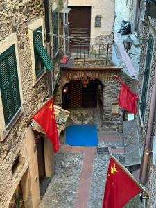 an alley with two chinese flags in front of a building at Il Dolce Rustico in Dolceacqua