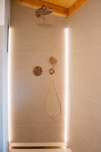 a shower with a hose attached to a wall at Rotbauernhof - Chalet - in Gutach
