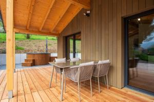 a patio with a table and chairs on a deck at Rotbauernhof - Chalet - in Gutach