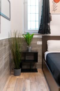 a bedroom with a bed and two potted plants at Suite Gli Ulivi in Colonna +61 photos