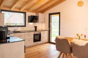 a kitchen with a table and a dining room at Rotbauernhof - Chalet - in Gutach +4 photos