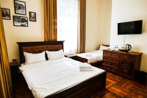 a bedroom with two beds and a television in it at Officers Boutique Hotel in Samarkand +19 photos