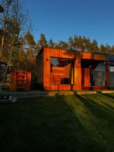 a wooden house with a grass field in front of it at Ciało odNowa in Lewiczyn