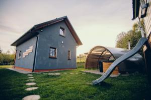 a blue house with a slide next to a building at Zacisze Krzeszów in Krzeszów