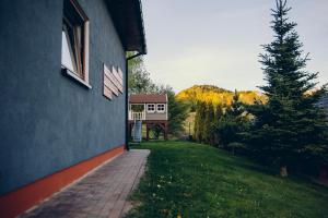a house with a brick walkway next to a yard at Zacisze Krzeszów in Krzeszów