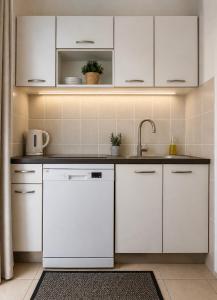 a kitchen with white cabinets and a sink at Apartman Ivanto in Makarska
