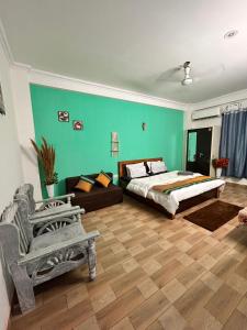 a bedroom with a large bed and a chair at Varāya 1RK Studio in Vrindāvan