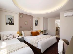 a bedroom with two beds with white sheets at İS Hotel in Antalya