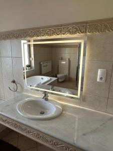 a bathroom with a sink and a tub and a mirror at Willa Rudno Nad Jeziorem in Rudno +44 photos
