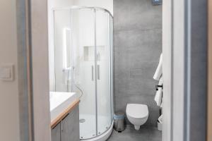 a bathroom with a glass shower and a toilet at AApartman Prime in Pécs +4 photos