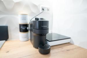 a coffee maker sitting on a wooden table with a cup at AApartman Prime in Pécs