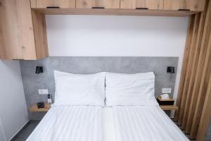 a bed with white pillows in a bedroom at AApartman Prime in Pécs