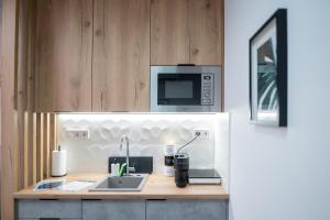 a kitchen with a counter with a sink and a microwave at AApartman Prime in Pécs