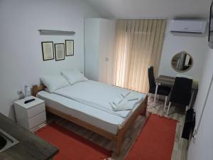 a small bedroom with a bed and a desk at APARTMANSKI SMEŠTAJ SOLARIS kod Aqua Parka STUDIO APARTMANI in Soko Banja +41 photos