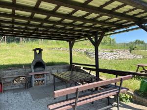 a picnic table and a fireplace under a pavilion at chalupa na Vysočině in Věž