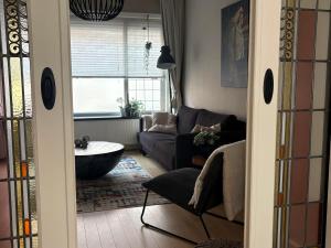 a living room with a couch and a table at Sfeervol appartement met tuin bij centrum & station in Dordrecht