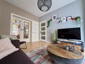 a living room with a coffee table in front of a tv at Sfeervol appartement met tuin bij centrum & station in Dordrecht