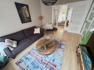 a living room with a couch and a table at Sfeervol appartement met tuin bij centrum & station in Dordrecht