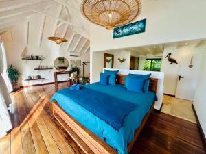 a bedroom with a large bed with blue pillows at Case Macalpa in Saint Barthelemy