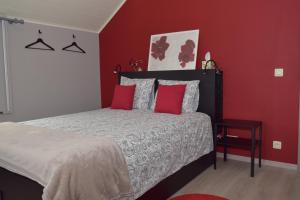 a bedroom with a bed with red walls at Chez Martine et Jean-Marc in Tintigny