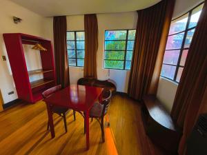 a dining room with a table and chairs and windows at Hostel Hotzenplotz Alegre in Valparaíso
