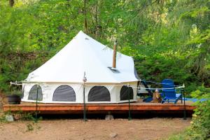 a white tent with a dog sitting in a chair at Creekside Retreat at Triangle Lake in Blachly