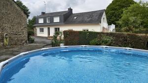 a large blue swimming pool in front of a house at Gîte de la Verdière Spa Pool Valley in Le Sourn