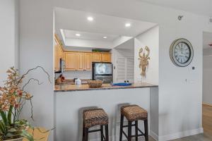 a kitchen with a counter and two bar stools at Easy Beach Walk Pools and Hot Tubs in Destin