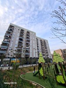 a large apartment building with a playground in front of it at Enea Apartments 8 in Tirana