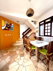 a dining room with a table and chairs at Triplex em Maracajaú a beira-mar in Maxaranguape