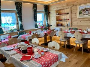 a dining room with tables and chairs with red napkins at Garni al Barance in Selva di Cadore +39 photos