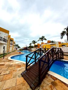a bridge over a swimming pool at a resort at Triplex em Maracajaú a beira-mar in Maxaranguape