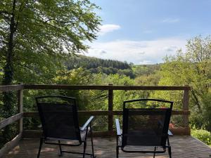 two chairs sitting on a deck with a view at Glanafon in Abergorlech