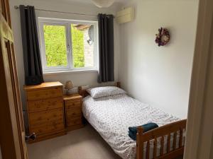 a small bedroom with a bed and a window at Glanafon in Abergorlech