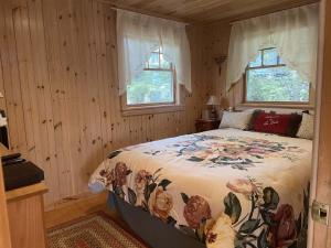 a bedroom with a bed and two windows at Sebago Waterfront Escape with Private Dock in Windham