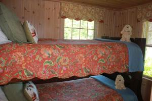 a bedroom with two beds with a red blanket at Sebago Waterfront Escape with Private Dock in Windham