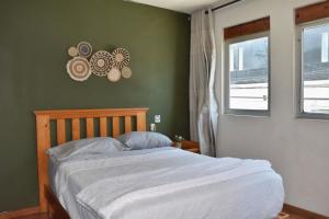 a bed in a bedroom with a green wall at Valentin House, very spacious and cozy. in San Luis Potosí