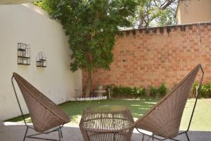 two chairs and a table in front of a brick wall at Valentin House, very spacious and cozy. in San Luis Potosí