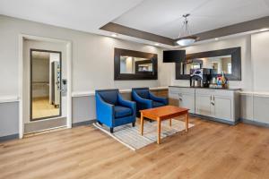 a kitchen with two blue chairs and a table at Suburban Studios Near Camp Lejeune in Jacksonville